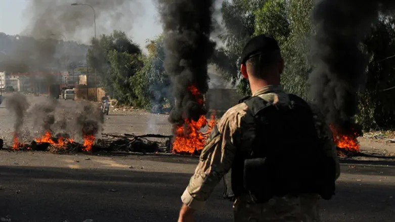 Soldier walks near burning tires during protests in Tripoli, Lebanon