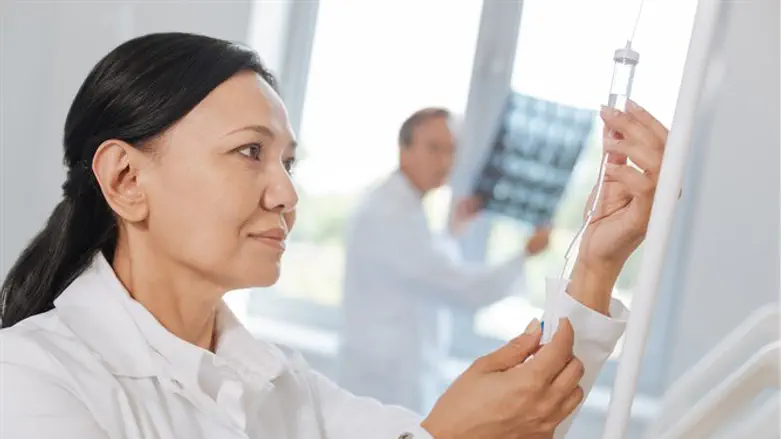 Nurse administering IV in hospital