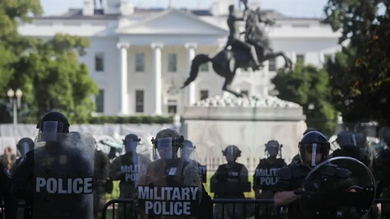 National Guard officers look on as demonstrators rally near the White House