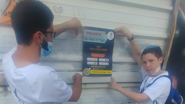 פעילי עמותת אחיעד תולים שלטים אודות קו הסיוע