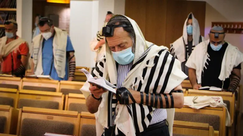 Men pray in the synagogue, wearing masks to prevent the spread of coronavirus