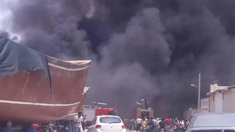Smoke rises from ships that are burning at the Iranian port of Bushehr