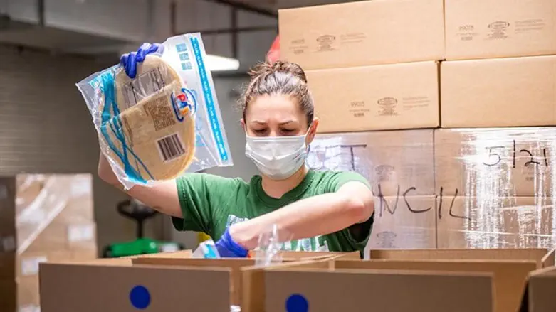 A volunteer packs groceries at the Met Council's warehouse in Brooklyn.