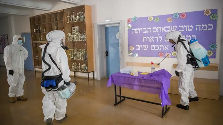 Cleaning workers disinfect the entrance to a high school in Jerusalem, June 3, 2