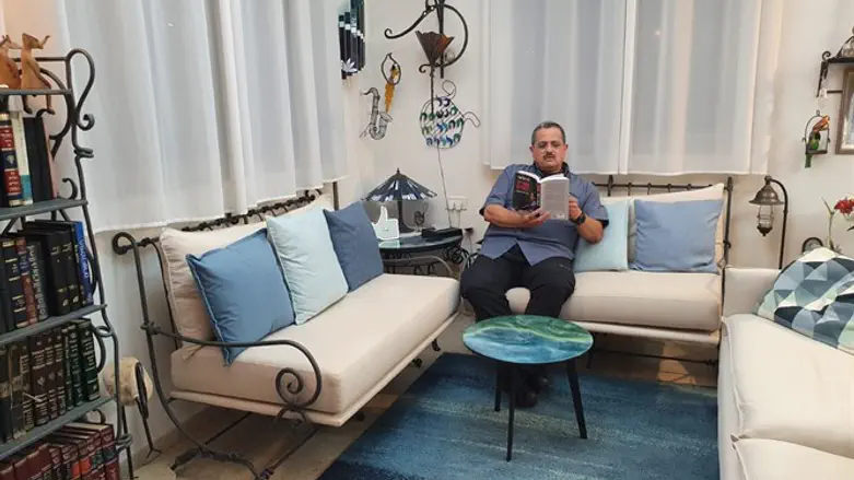 רוני אלשיך בביתו עם ספרו החדש