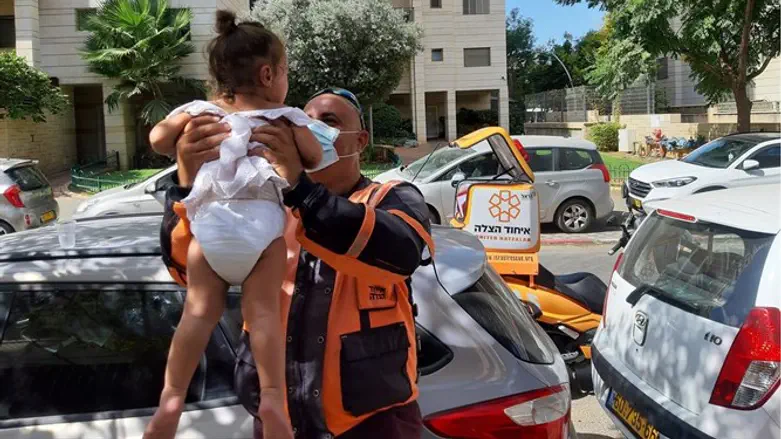 Alan Malka holding the infant girl he rescued