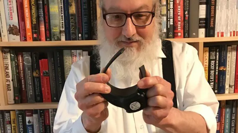 Jonathan Pollard holding up the electronic tracker