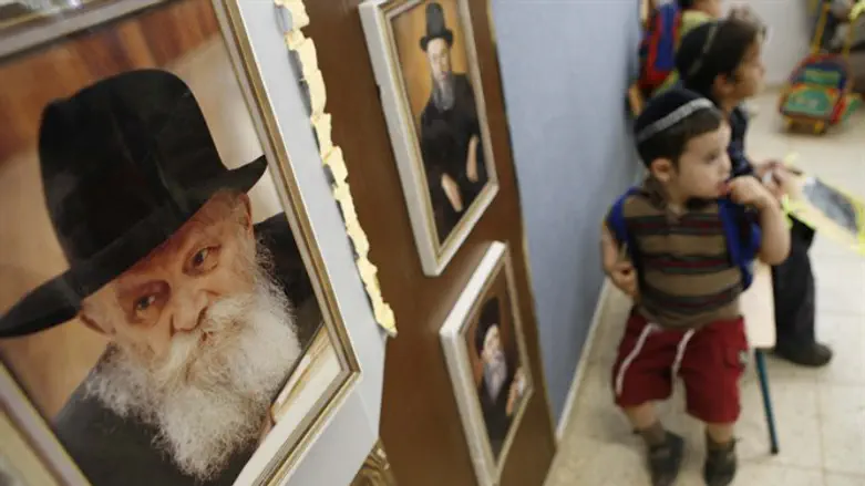Jewish boy sits next to picture of Lubavitcher Rebbe