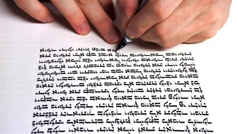 Scribe writing Torah scroll